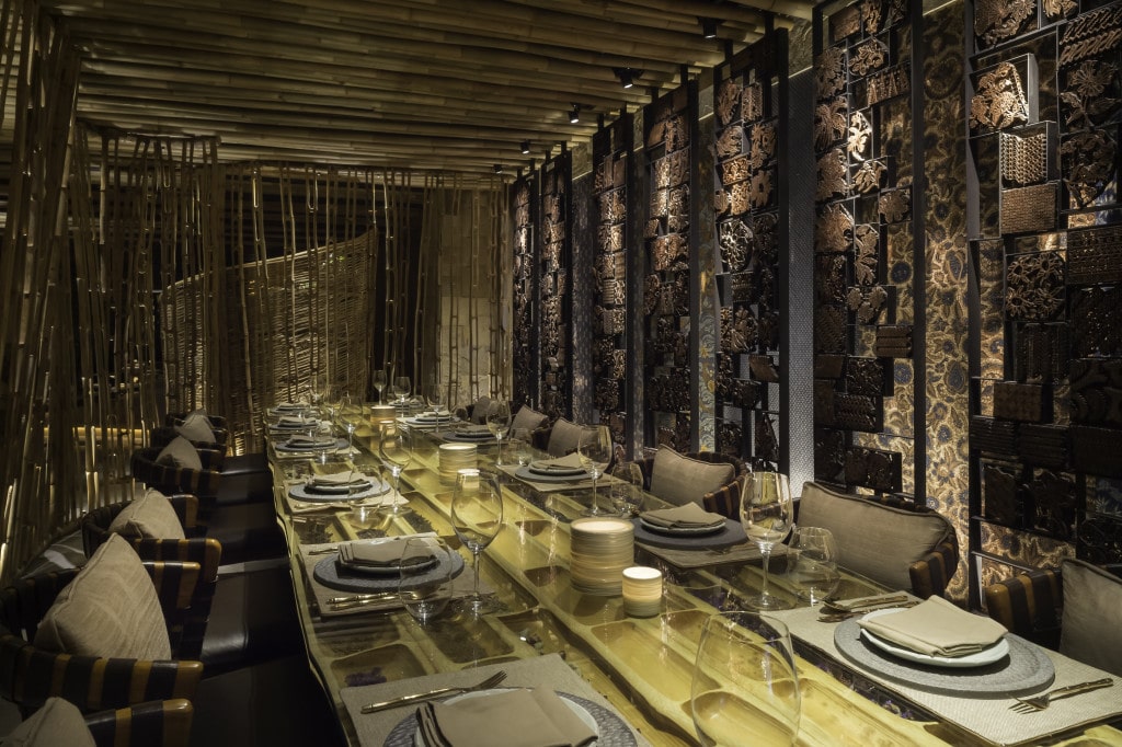Semi-private dining room with antique batik tjap wall feature by Ibuku